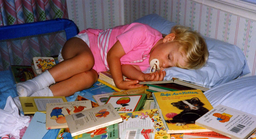 child sleeping in books